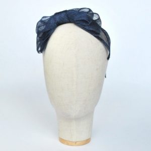 Front view of Navy Blue Large Sinamay Bow Fascinator, worn to the right