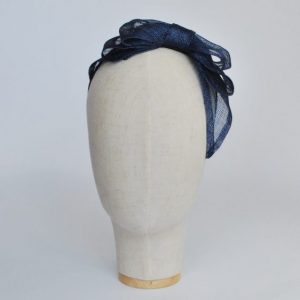 Front view of Navy Blue Large Sinamay Bow Fascinator, worn to the left