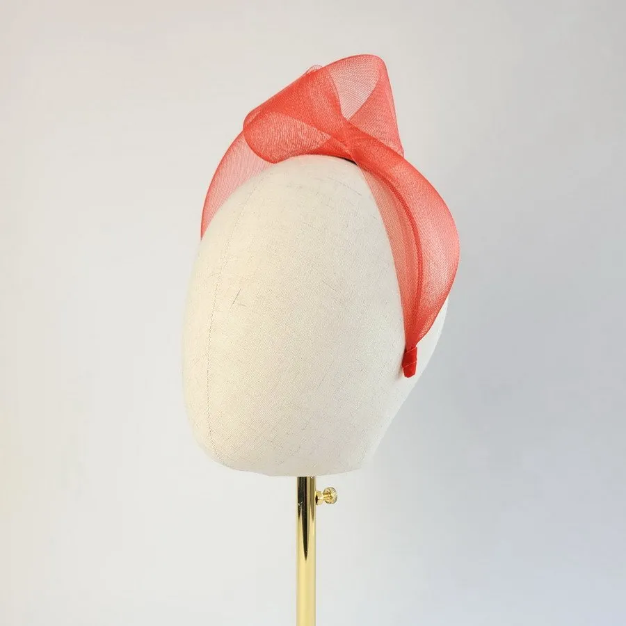 Red mesh knotted hair accessory worn to the left of the head