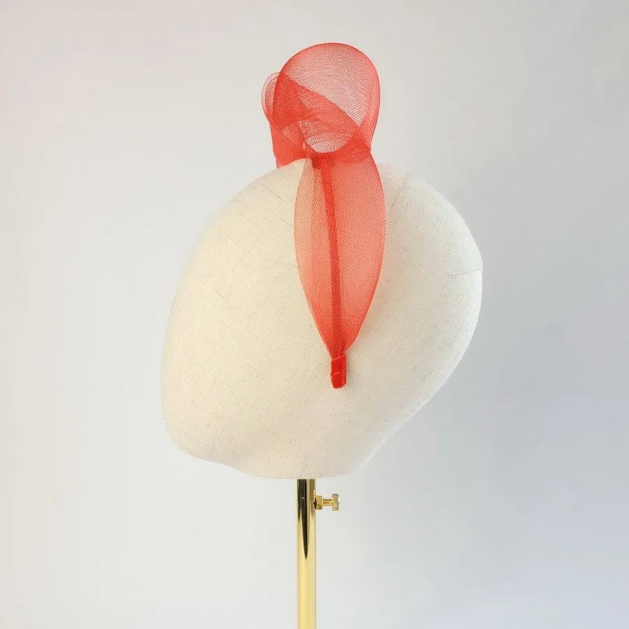 Red vegan friendly knotted headband worn to the left of the head