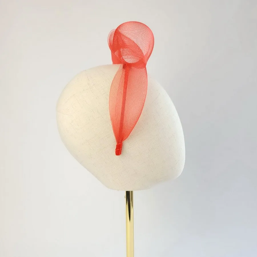 Red statement knot headband worn to the right of the head