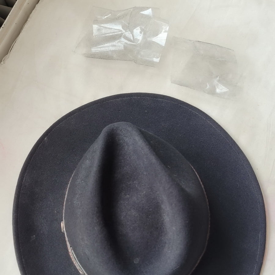Tape used to lift surface dust and animal fur from a wool felt Stetson hat.